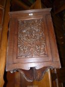 An Oak wall hanging Corner Cupboard, the door intricately carved with intertwined serpents,