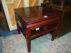 An Eastern hardwood low Bedside Table having a frieze drawer and standing on tapering square legs,