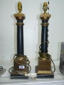 A pair of table Lamp bases with smooth black columns on gold coloured square bases and