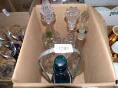 A box of assorted glass decanters and one bottle stand.