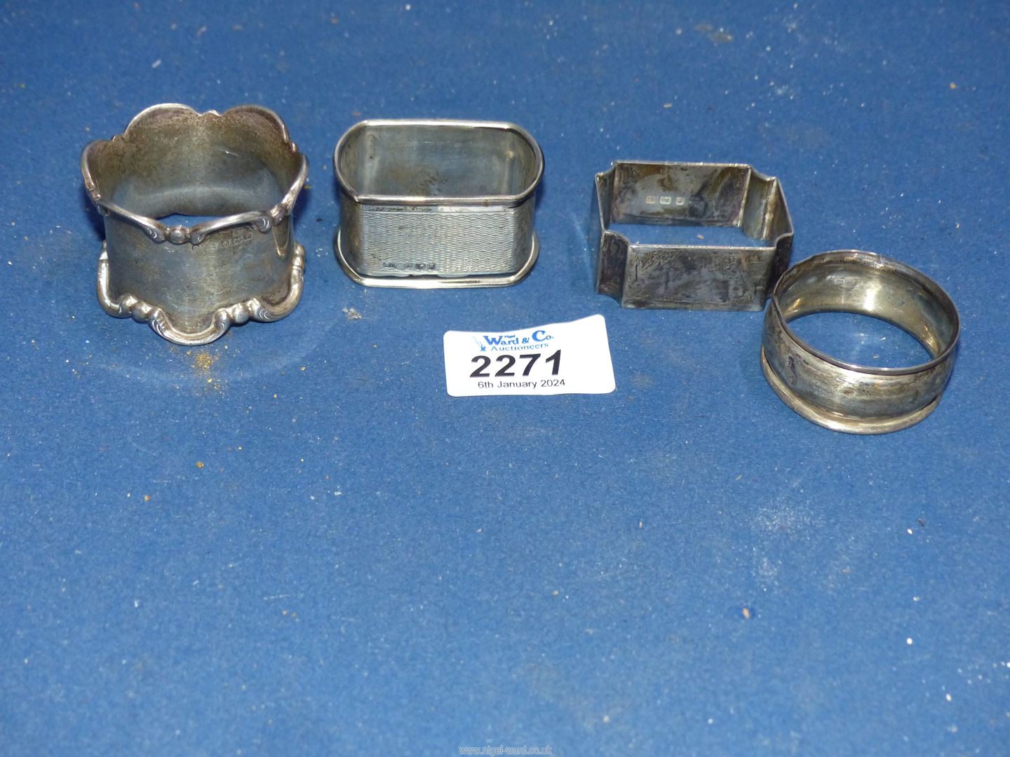 Four Silver napkin rings in various shapes, one engine turned.