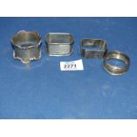 Four Silver napkin rings in various shapes, one engine turned.