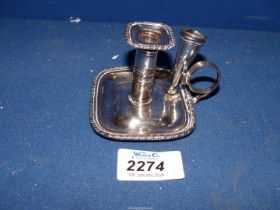 A silver plated chamberstick with detachable snuffer.
