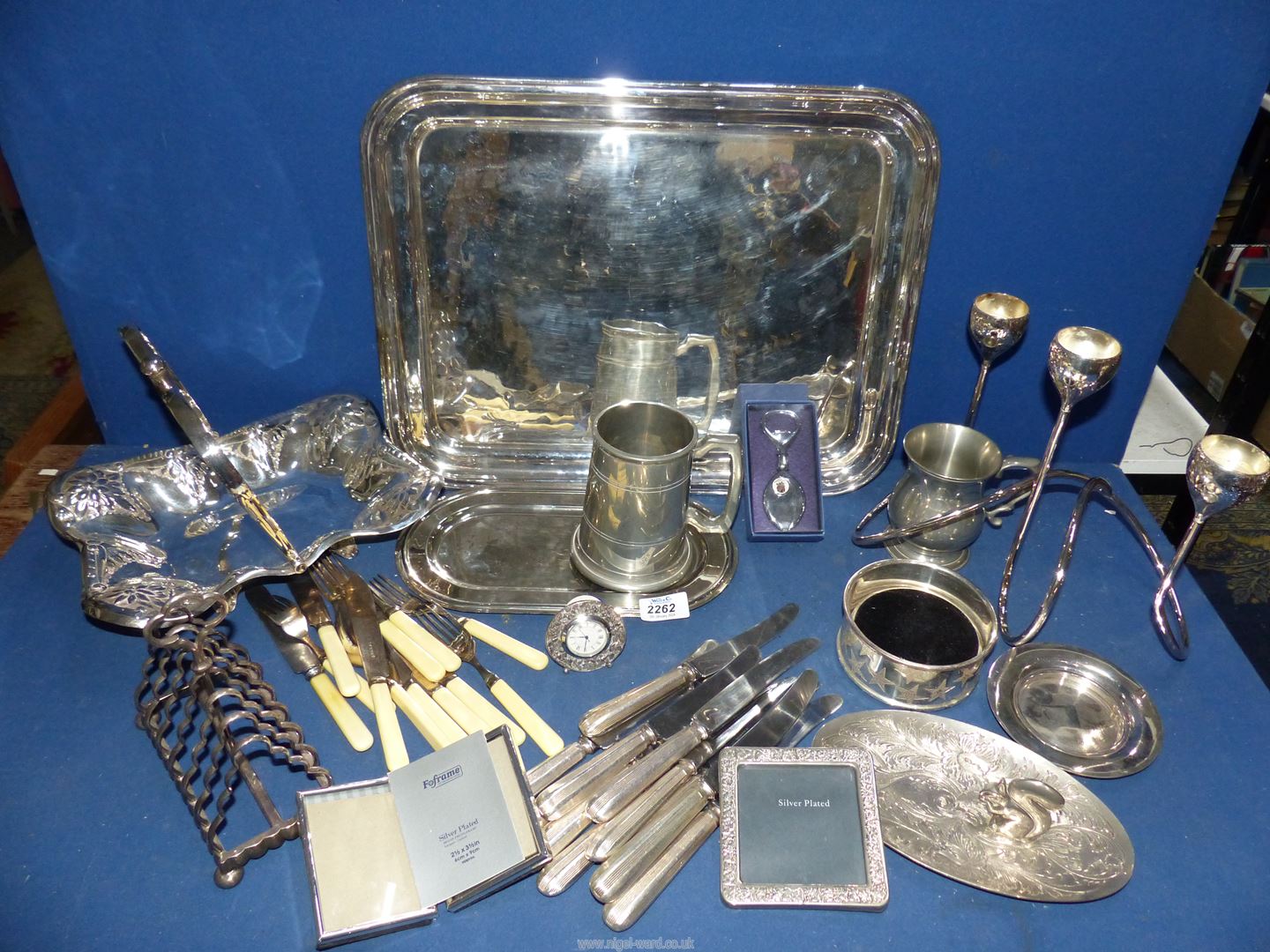 A quantity of plated items including toast rack, dinner knives, small tray, fruit bowl,
