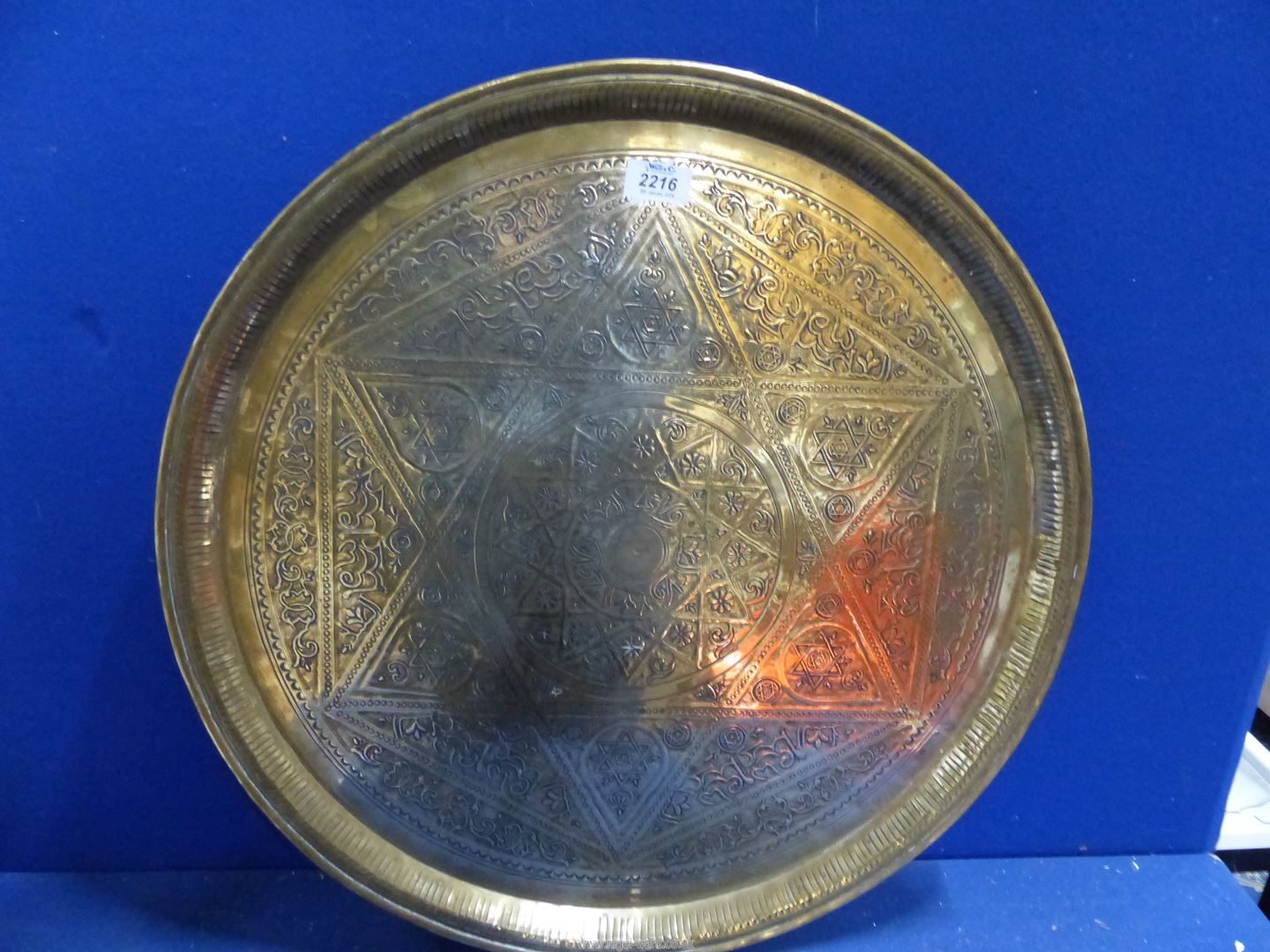 A large brass hand beaten Benares tray with Arabic script and designs, of some age, 23" diameter.