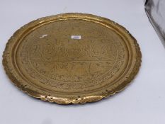 A large brass charger with pierced rims and Eastern style decoration, some bends to the rim,
