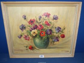 A framed Oil on board of a still life of anemones in a green vase, signed lower right Haselman,