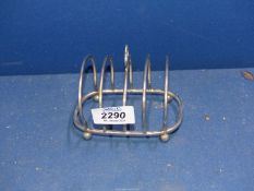 A Toast rack on ball feet stamped 'solid silver'.