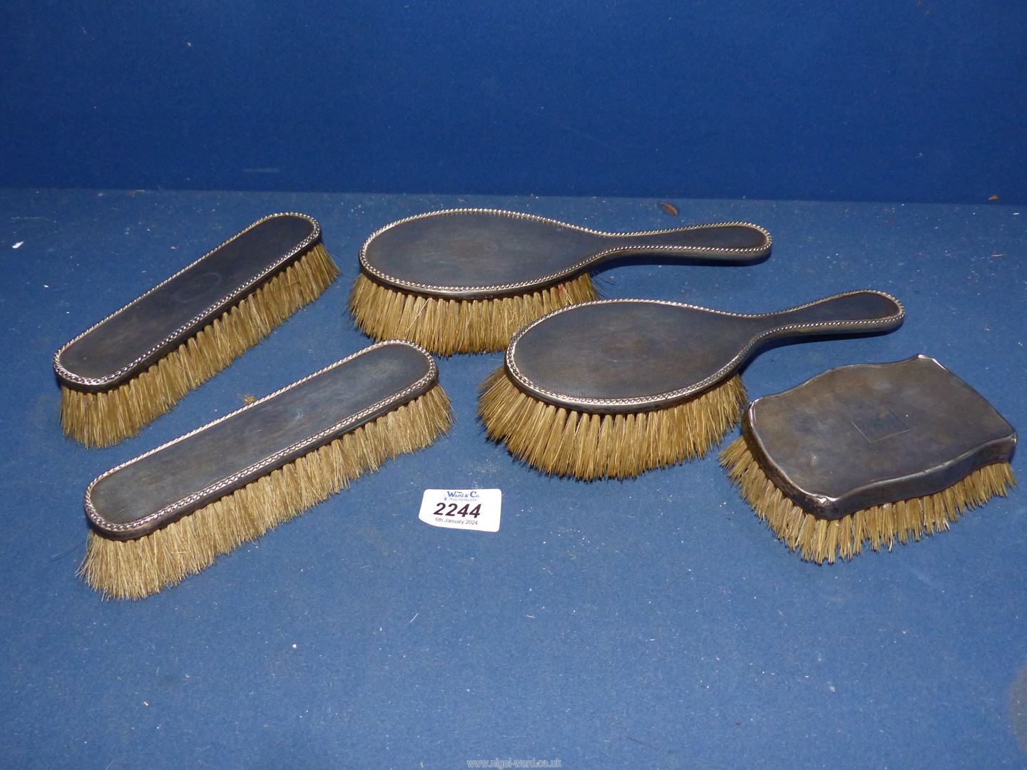 Two silver backed hairbrushes with two matching clothes brushes, date letter 'O' possibly 1913,