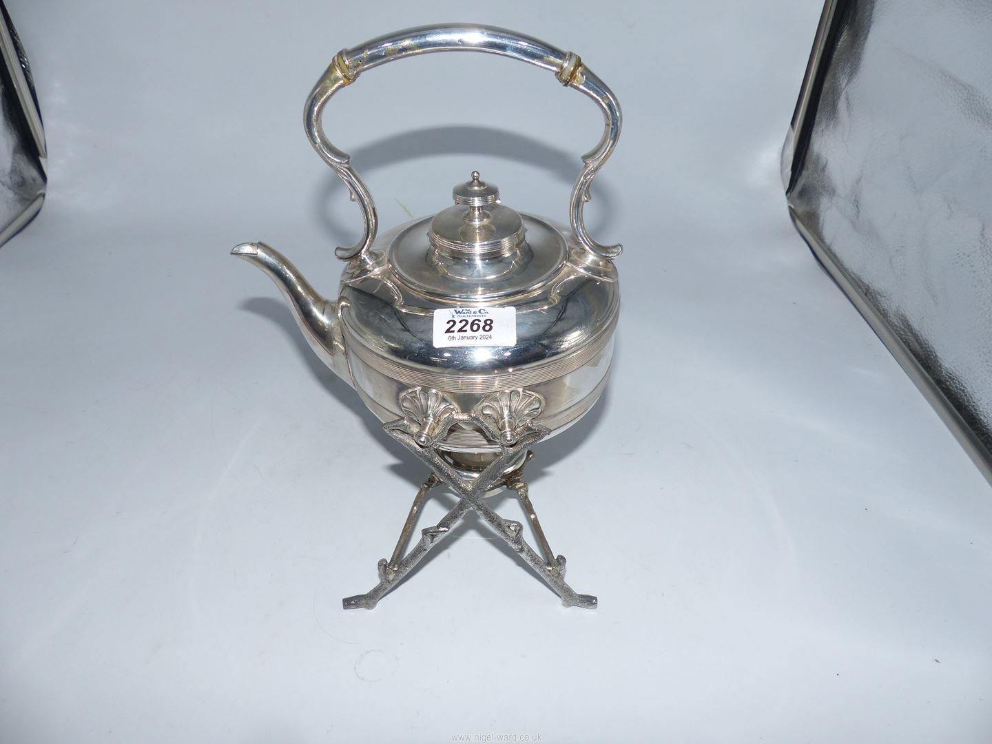 A silver plated spirit kettle with a burner.