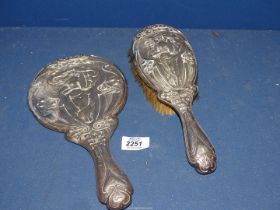 A silver backed Art Nouveau hand Mirror and matched hair brush, Birmingham 1906, some dings.