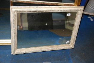A wooden framed mirror - 28" x 20".