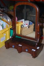 A Mahogany swing mirror with three drawers and china handles.