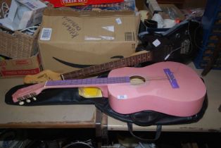 A pink Guitar and case, plus a Electric Guitar.