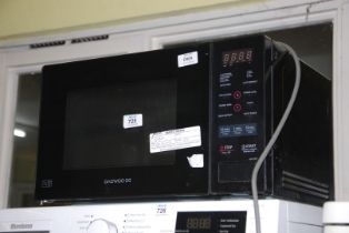 A 'Daewoo' microwave with instructions.