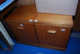 A pair of small Teak finished Cupboards with pull out trays to the top.