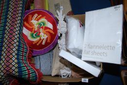 A box of new sheets, cushions plus a wall plaque.