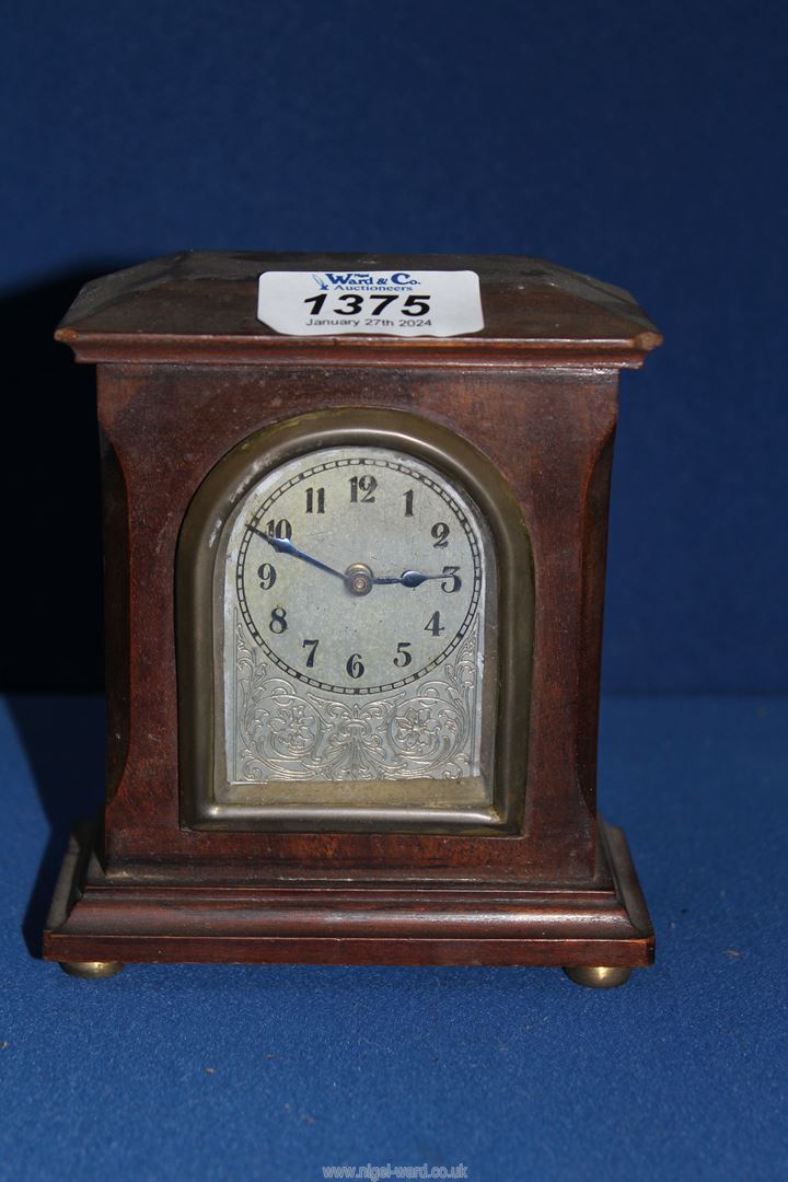 A small mantle clock with Arabic numerals, 5'' tall.