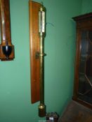 A brass cased cylindrical Marine mercurial Barometer complete with gimballed mount and a hardwood