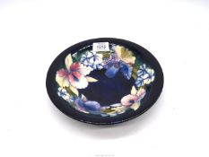 A Moorcroft 'Orchid' bowl in deep blue background,