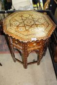 An octagonal topped side table with folding base having decorative inlaid decoration 20" wide x 20