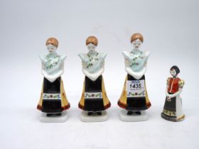 A set of three Hollohaza figures of young girls in traditional dress and one other.