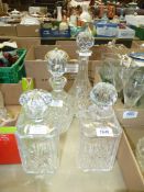 Four cut glass decanters including two square, one by Thomas Webb.