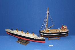 A hobby papier mache model of 'R.M.S Titanic' and a wooden model of a fishing boat.