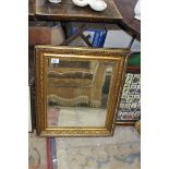 A heavy gilt framed bevelled mirror, some chips, approx. 59cm x 50cm.