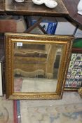 A heavy gilt framed bevelled mirror, some chips, approx. 59cm x 50cm.