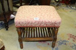 A rectangular Stool standing on turned legs united by a slatted lower shelf,