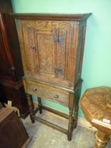 An appealing carved Oak Cupboard on stand,