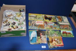 A box of animal related cigarette cards and postcards.