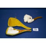 Two meerschaum Pipes, one pipe cased, carved with the head of a bearded Arab with headdress,