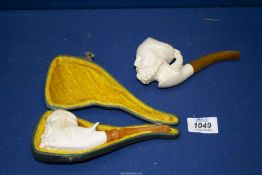 Two meerschaum Pipes, one pipe cased, carved with the head of a bearded Arab with headdress,