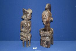 A Tribal female figure seated on three legged stool,