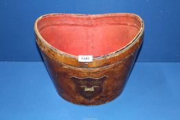 A leather covered hatbox with family crest to the front of three crowns and a castle, lid missing.