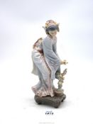 A Lladro figure of an oriental girl with garland in her hair and flower in her hand,