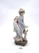 A Lladro figure of an oriental girl with garland in her hair and flower in her hand,
