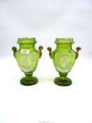 A pair of Mary Gregory green glass vases having scroll handles 8 3/4" with painted figure of a boy