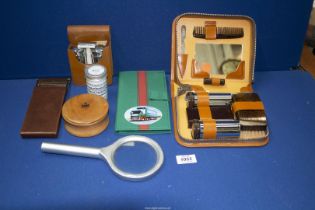 A small tray of ephemera namely an unused men's grooming cased set, a travelling shaving set,