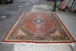 A border patterned and fringed carpet in floral pattern of red,