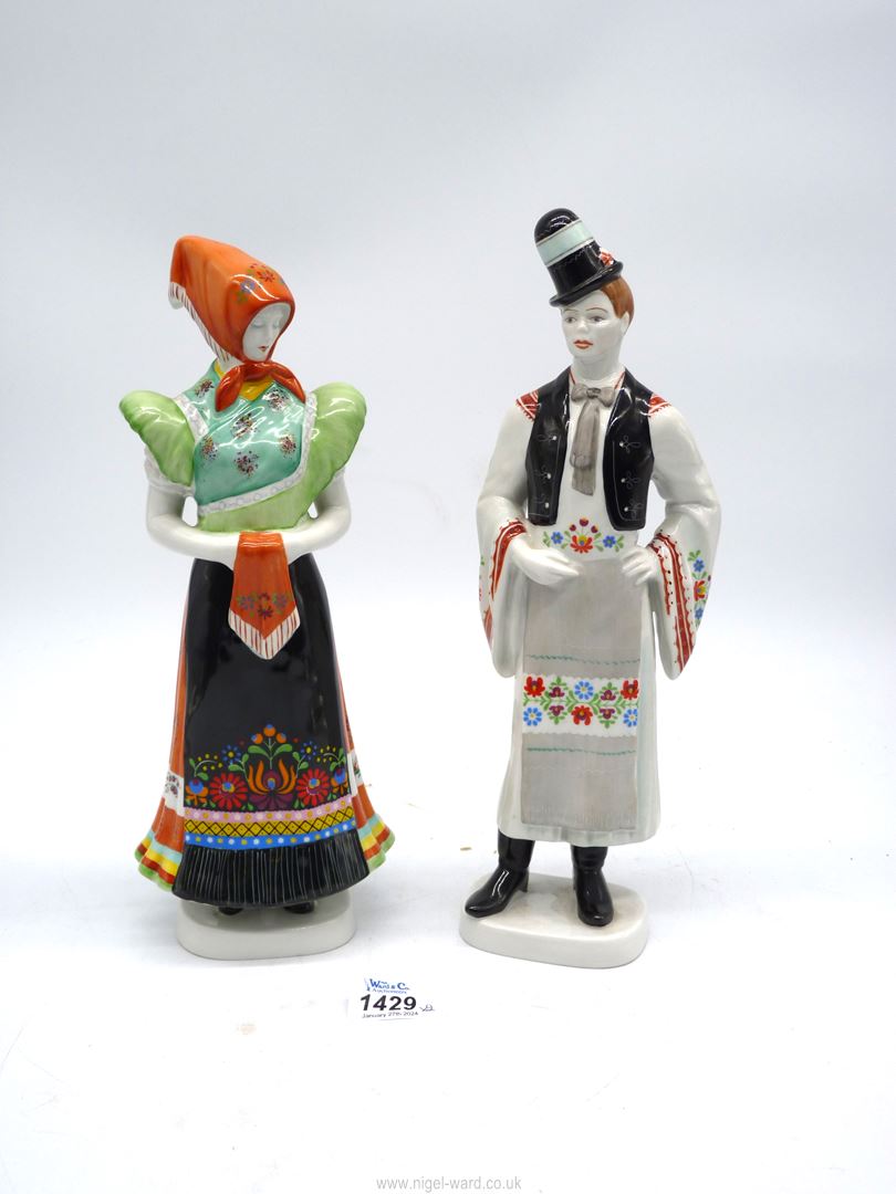 Two Hollohaza porcelain figures of a lady and gent in traditional dress.