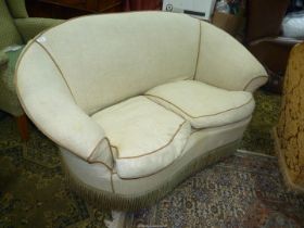 An elegant two seater Settee of kidney shape with a fringed frieze and finished in beige fabric.