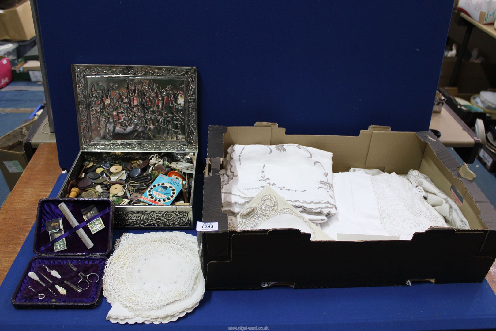 A quantity of embroidered linen, doilies, table cloths, box of buttons and buckles, etc.
