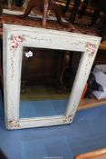 A cream and floral painted bevelled wall hanging mirror, 24 1/2'' x 32 1/4'' approximately.