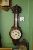 A carved Oak Aneroid Barometer, mercury thermostat.