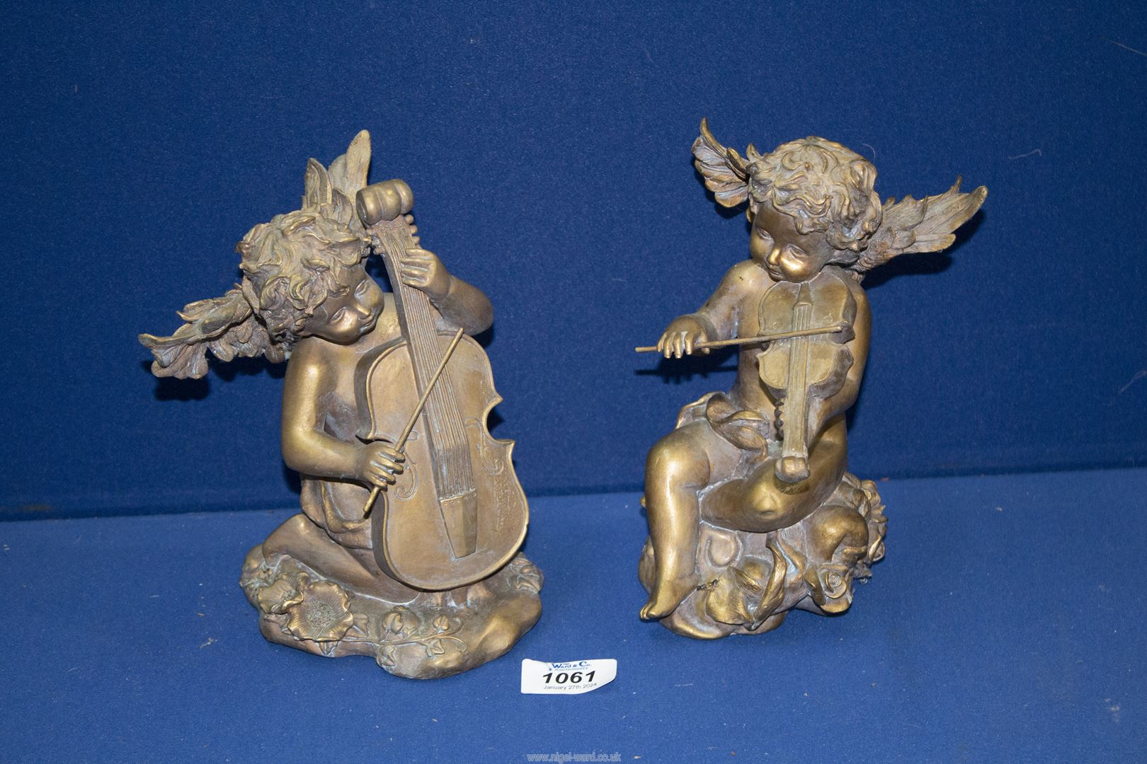 A pair of gilt finish Cherubs, playing a cello and a violin, 8'' tall.