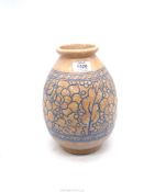 A Charlotte Rhead Pottery vase in muted orange and blue with floral tube lined decoration, 10" tall.