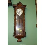 A wall clock with glass fronted case, Roman numerals with seconds dial, with pendulum but no key.